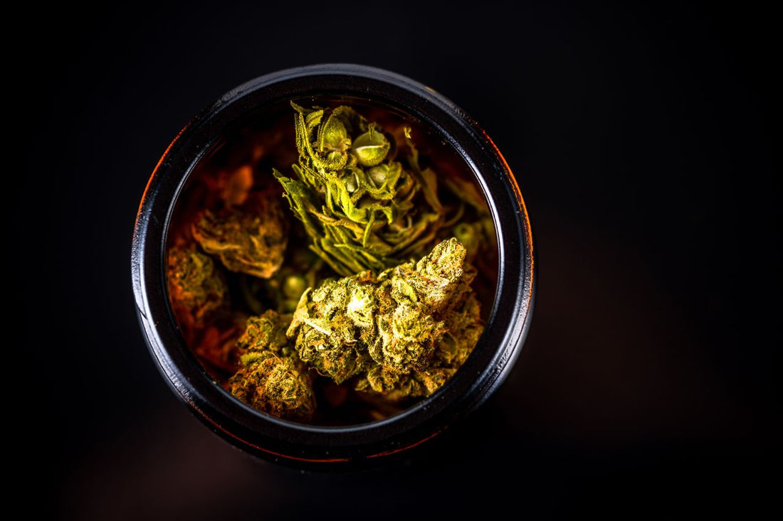 Un pot rempli de fleurs et de bourgeons de cannabis