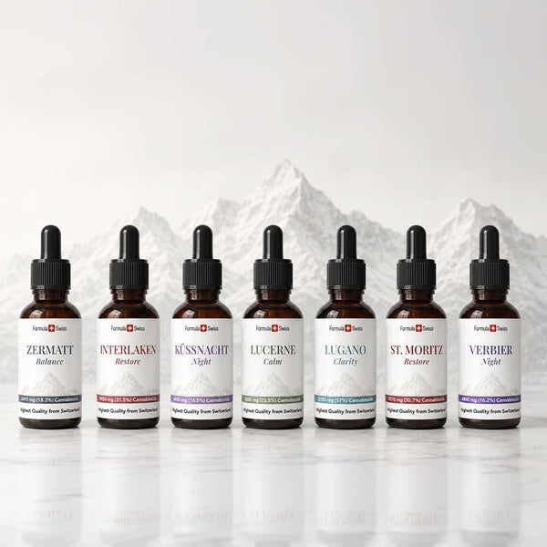 Formule Swiss CBD collection d’huile avec sept bouteilles de compte-gouttes ambres exposées devant un fond de montagne suisse.